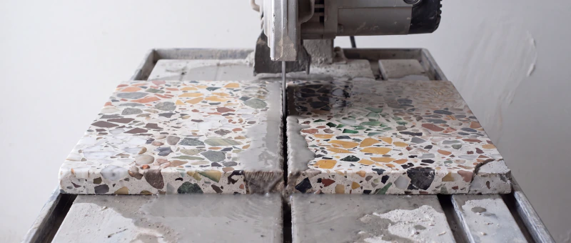 A terrazzo slab on the saw bed, part way through a cut