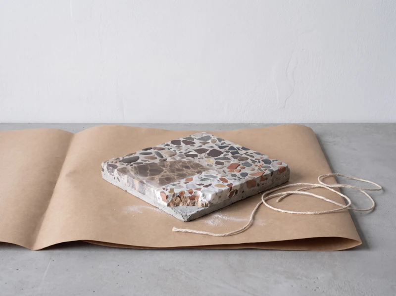 A cut sample on brown paper with a length of string, ready to post