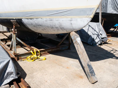 A hull on stands with her topsides faired and primed.