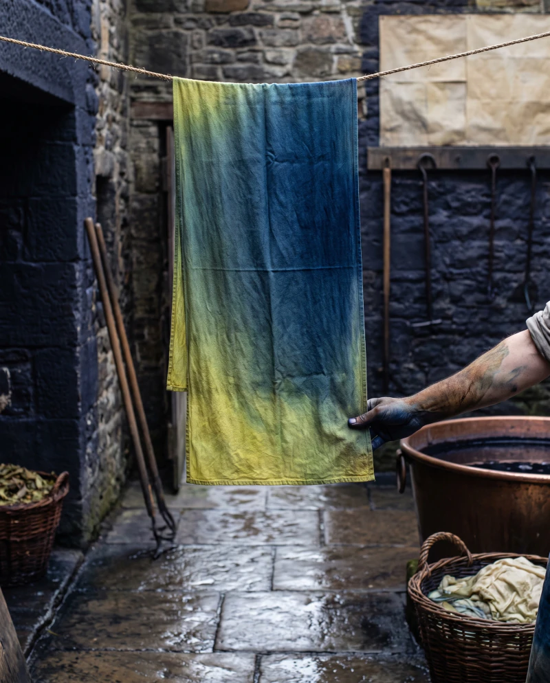 Dyed cloth hanging in the yard turning from green to blue in the air