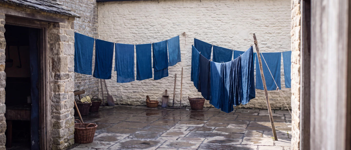 Lines of blue cloth drying in a walled yard
